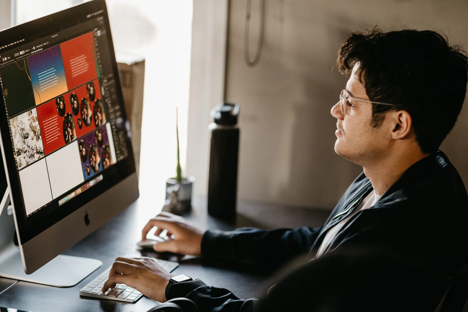 Designer developing a poster and visual layout on a large desktop screen